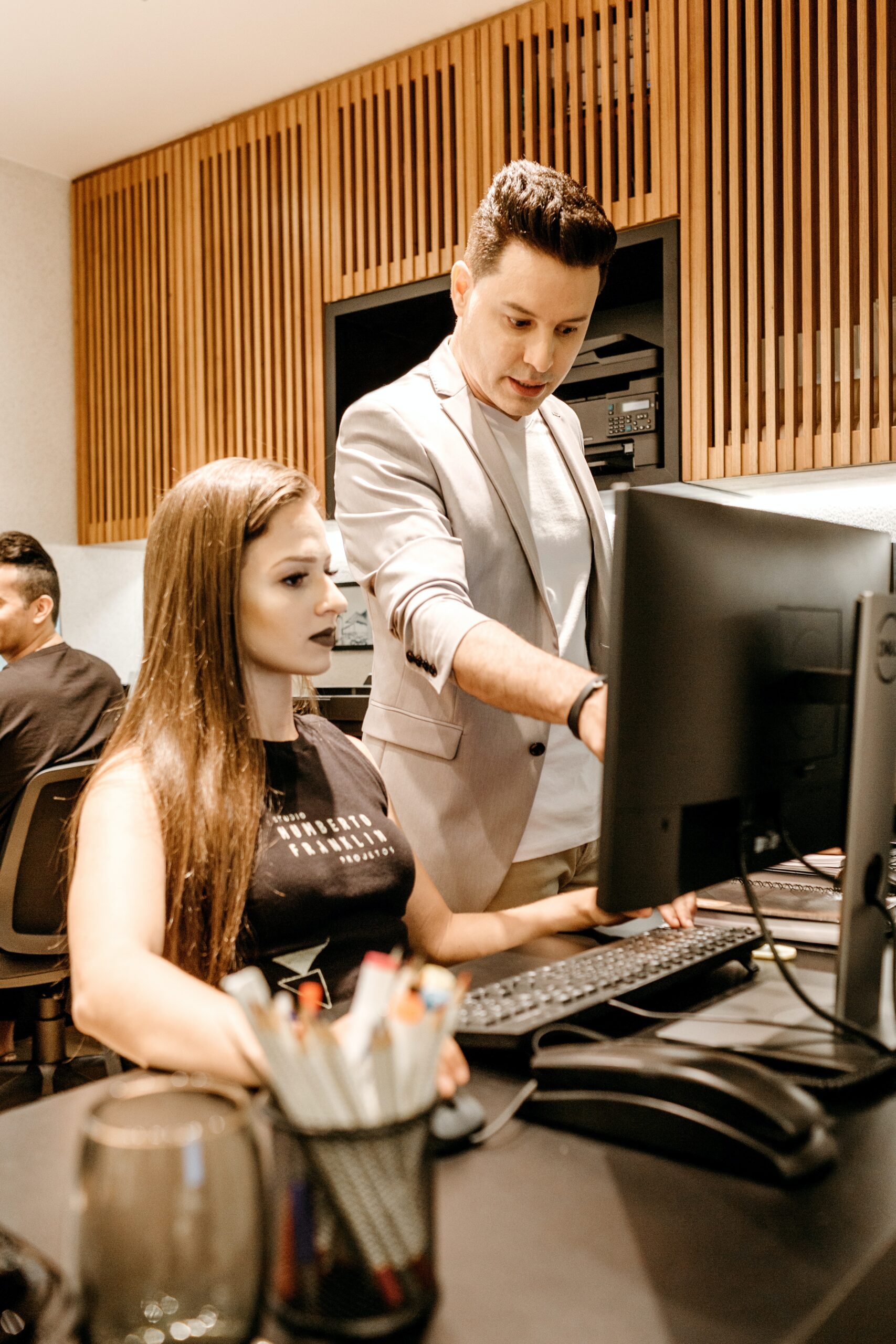 a man and woman are working on a computer